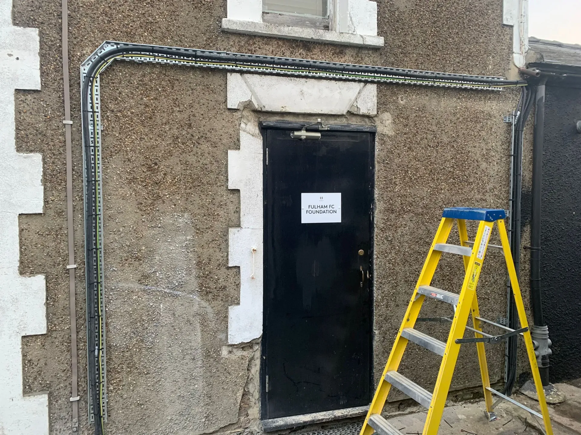 Commercial galvanized cable tray installation on exterior brick wall