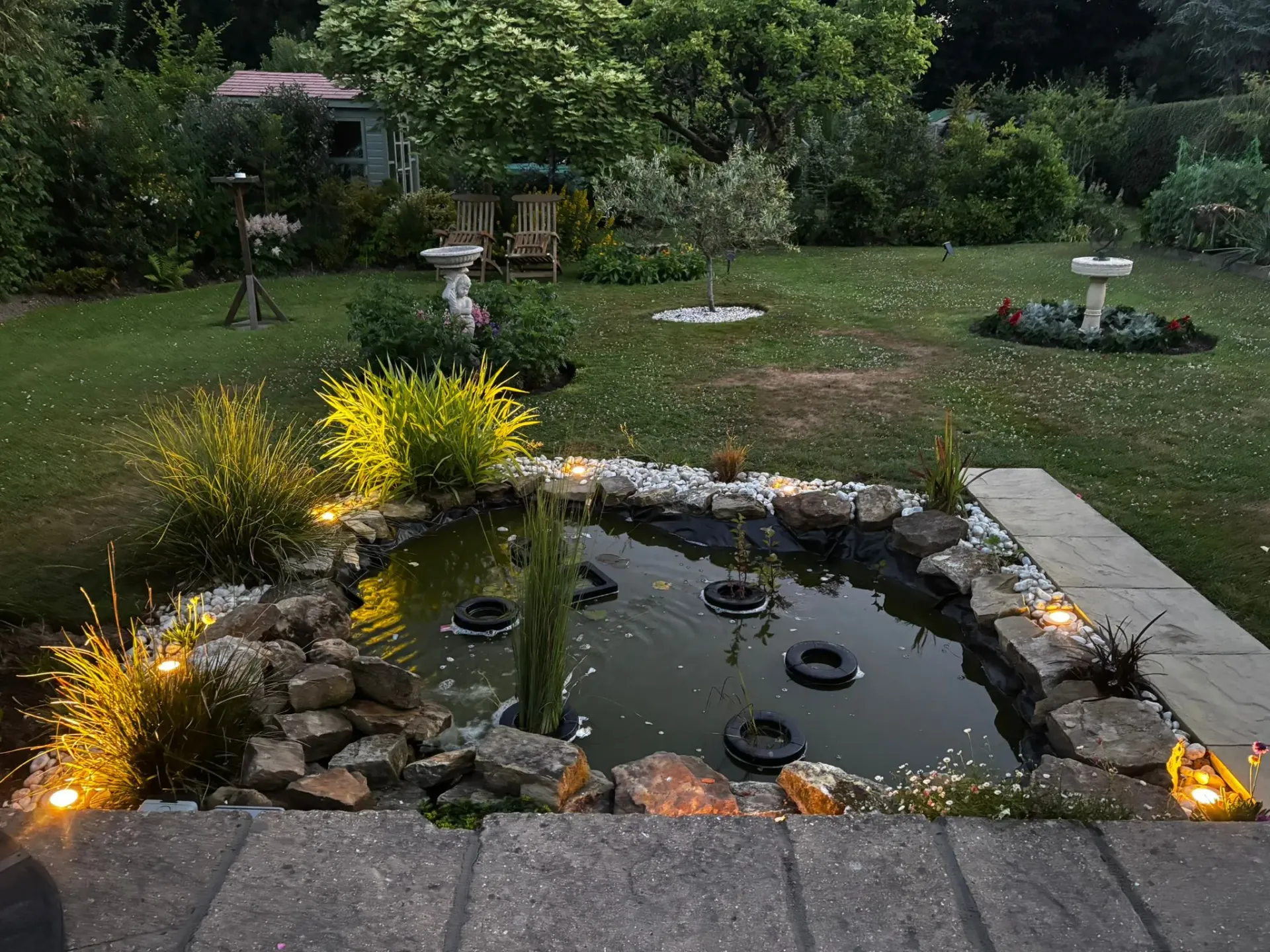 Professionally installed outdoor garden lighting around a garden pond in West Sussex.